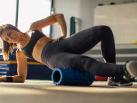 A woman foam rolling her hip.