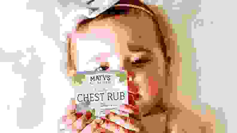 Baby appearing to read box ingredients of Maty's chest rub.