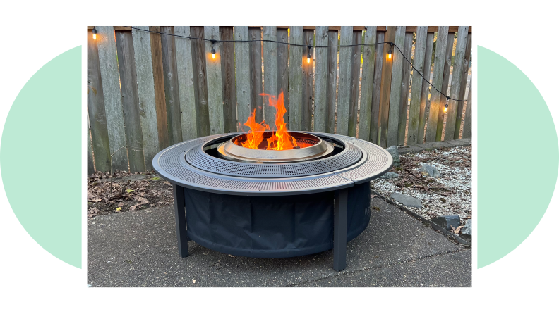Side view of the Solo Stove Surround with a flame burning in the firepit.