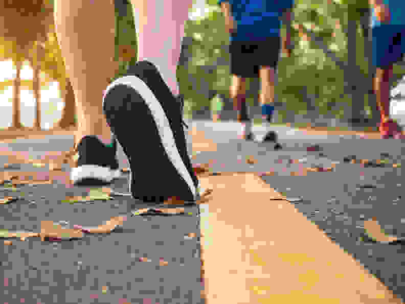 woman walks along a paved path in a park