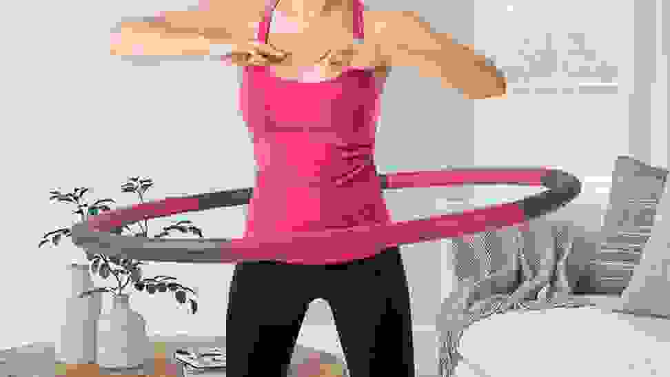 A model demonstrates proper use of the Neoweek weighted hula hoop.