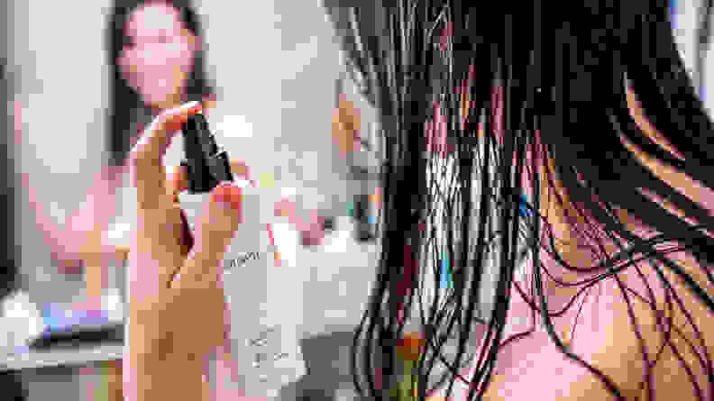 A woman spraying detangler into her wet hair.