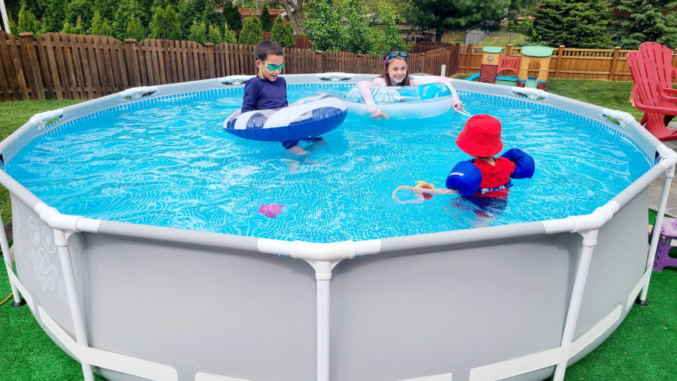 Three children swim and play in an above-ground Intex pool.