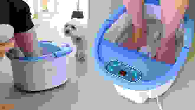 Person soaking feet in foot bath and massager filled with water.