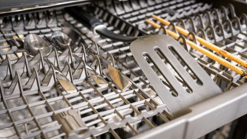 A close-up of the Whirlpool WDT750SAKZ dishwasher's third rack, which features a tight square grid latticework. There's a spatula and other larger utensils stored up there.