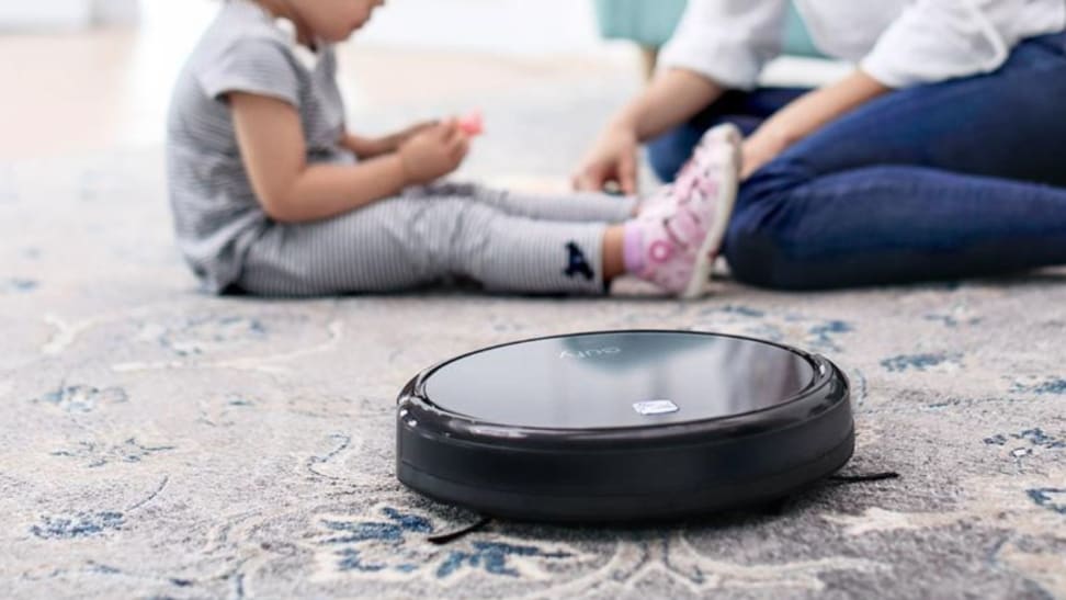 baby and parent sitting on the floor next to Eufy 11S