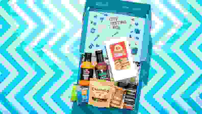 City Tasting Box's Memphis-themed box, open, showcasing all of the food products inside, on a blue zigzag pattern