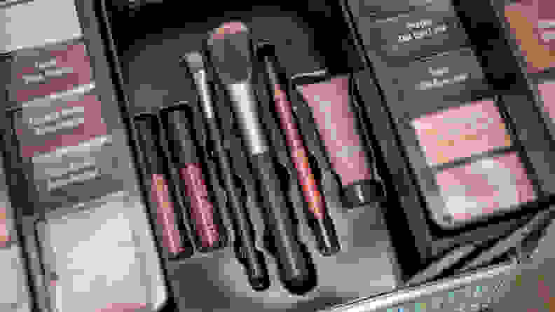 A closeup on the lip glosses and brushes in an Ulta makeup kit.