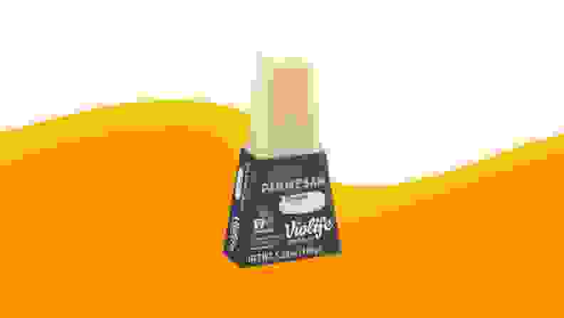 A product photo of Violife Parmesan on an orange and beige background.