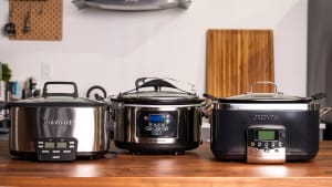 Three of the best slow cookers we tested (Cuisinart, Hamilton Beach, and GreenPan) are displayed on a kitchen counter.