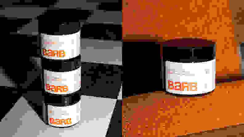 Three tubs of cream stacked on top of each other and then another tub next to them on an orange background