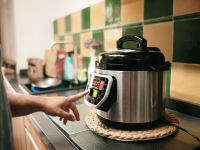 Person pressing button on Instant Pot with finger.