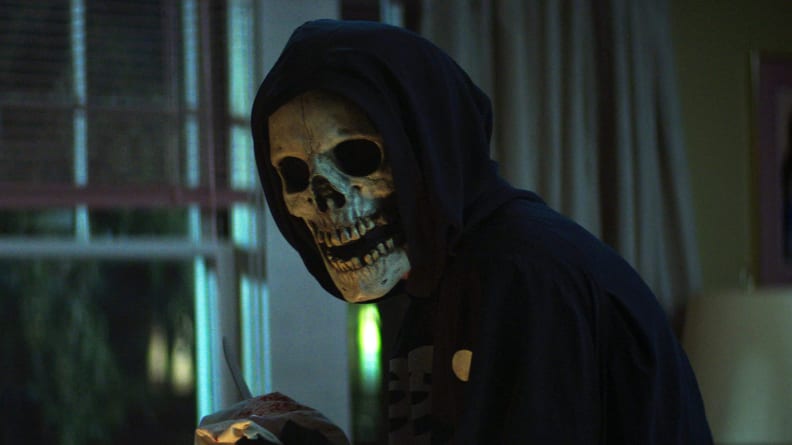 A person in a skeleton mask against a window, in a scene from "Fear Street: Part One 1994."