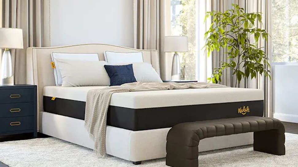 A Nolah Signature mattress with pillows and a blanket on top of it in a bedroom.