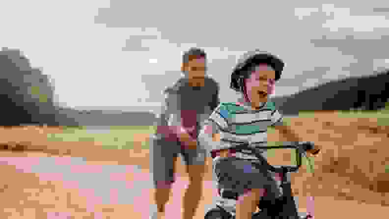 A child looks thrilled as they master their first bike ride