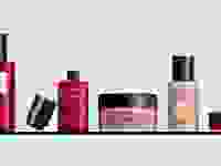 灰色背景的架子上放着五个香奈儿的化妆品、护肤品和香氛瓶。