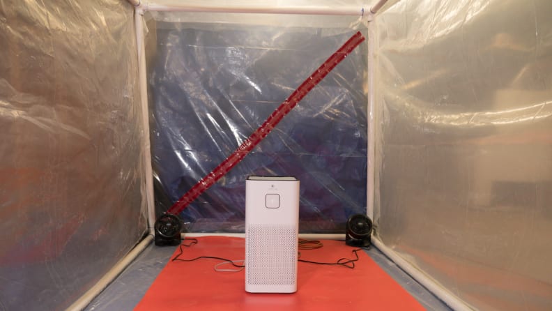 An air purifier stands in front of an air tight room.