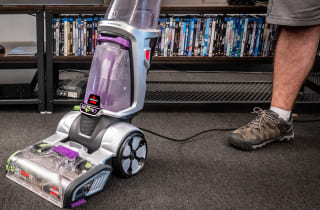 A vacuum stands in a room on a carpet
