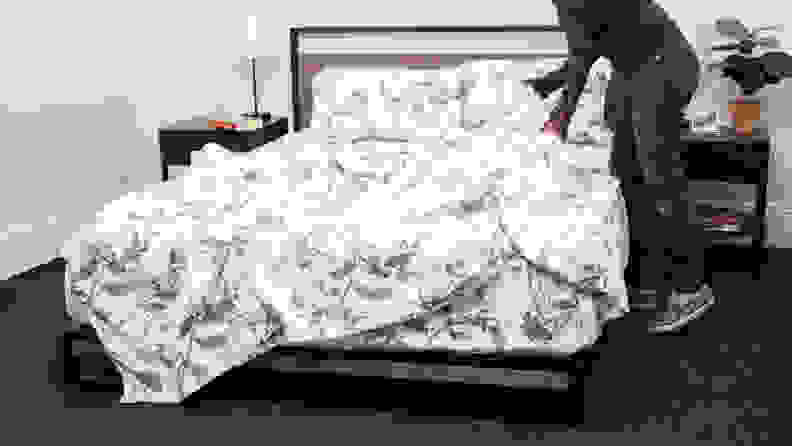 Person making bed with Pinzon floral flannel sheets