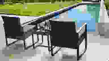 A 3-piece patio set placed in front of an in-ground pool.