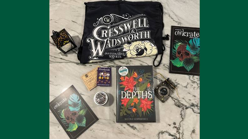 An image of the contents of an OwlCrate box, including a signed, OwlCrate exclusive copy of The Depths by Nicole Lesperance, a Cresswell and Wadsworth drawstring bag inspired by Stalking Jack the Ripper, a "One Flesh, One End" candle inspired by Gideon the Ninth, a lantern inspired by "Gallant," a jewelry box, a bag holder, an enamel pin inspired by Ember in the Ashes by Sabaa Tahir