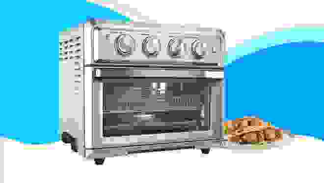 A stainless steel toaster oven against a blue background.