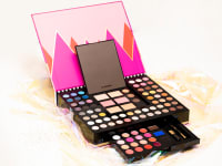 A large Sephora makeup palette sits on glittery cellophane.