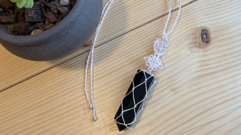 Obsidian and clear quartz sitting on table next to potted plant.