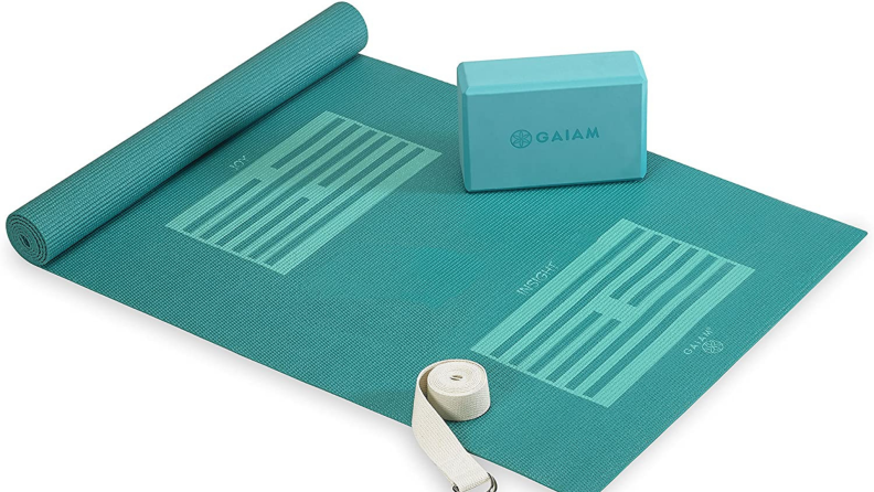 Product shot of teal yoga mat, yoga block and yoga strap.