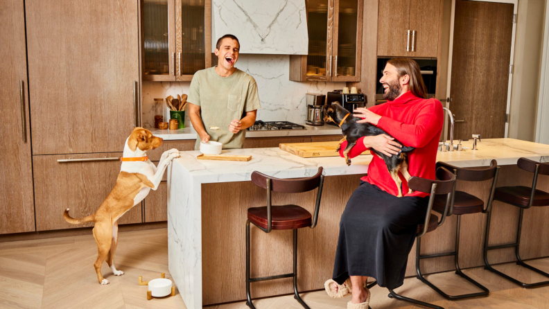 Antoni and Jonathan with their pets in a kitchen.