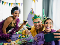 People wearing gold, purple, and green clothing and makeup to celebrate Mardi Gras.