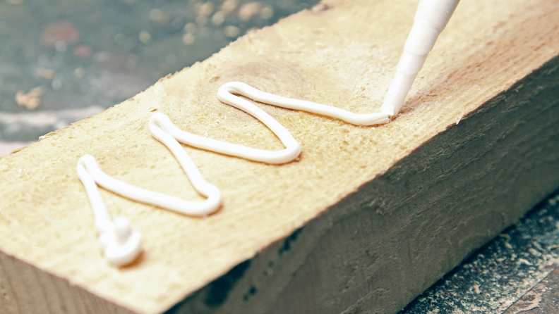 Putting glue on a piece of wood.