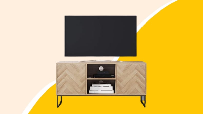 A wooden television console with television on top.