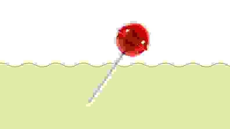A red lollipop on a green and beige background