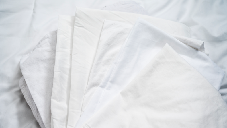 Five white sheets are folded and spread out.
