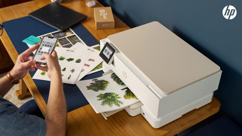 A man prints full-color documents from his phone using an HP printer included in the HP All-In Plan.