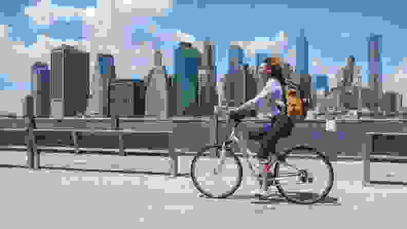 Woman riding bike through city.