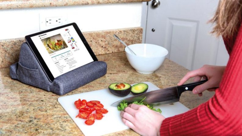 Person typing on tablet being propped up on table