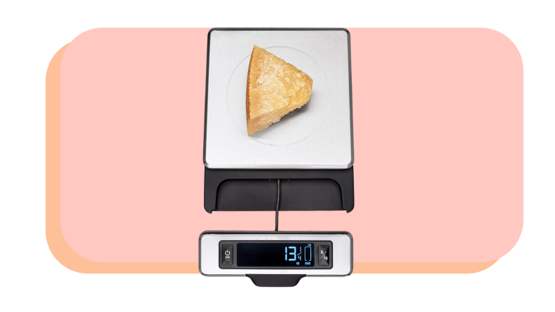Wedge of cheese sitting on top food scale.