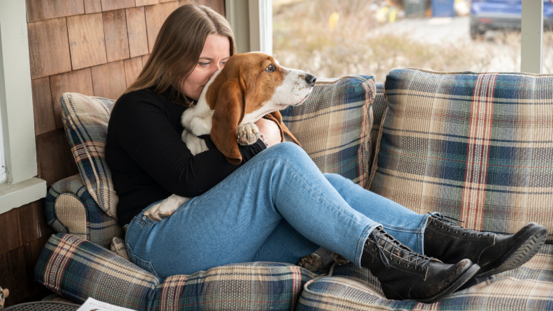 Girl wearing American Eagle jeans holds her dog.