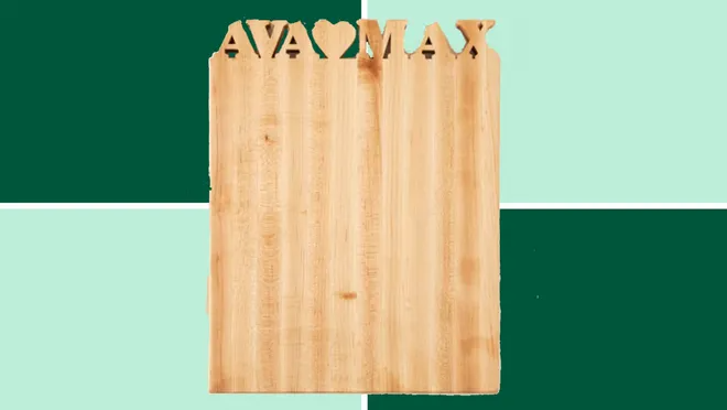 Personalized Cutting Board from Uncommon Goods on a dark and light green background.