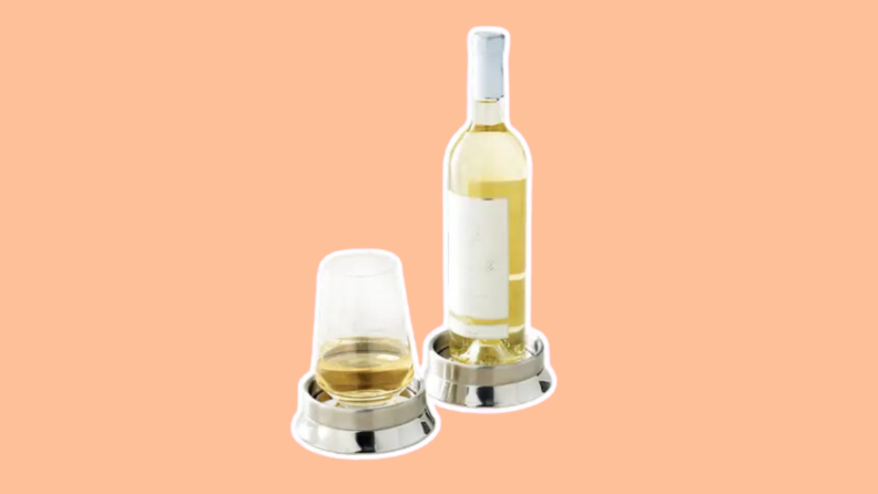 A glass of wine and a bottle sit atop a pair of Frontgate Wine Chilling Coasters.