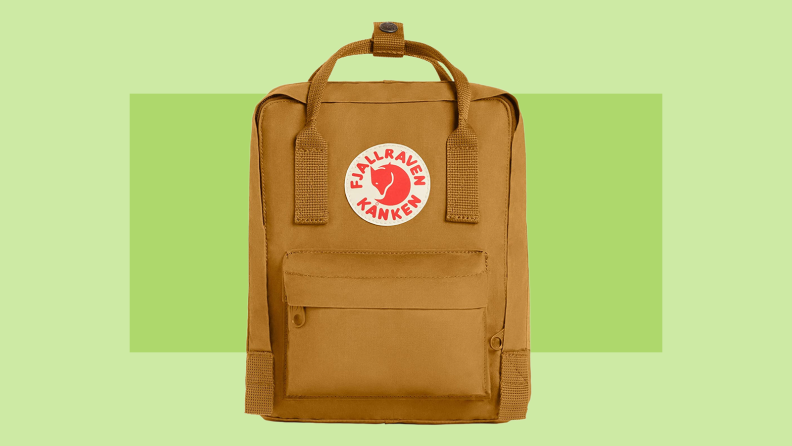 A mustard yellow Fjallraven backpack on a green background