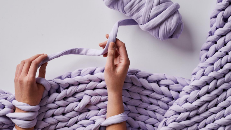 Two hands knitting a weighted blanket