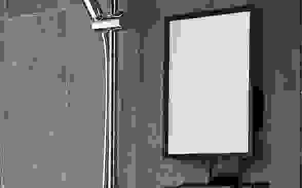 A fogless shower mirror being used for music and for a man to shave.