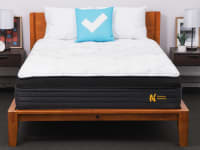 A bedroom with a Nolah Evolution 15 mattress and Reviewed, blue, pillow.