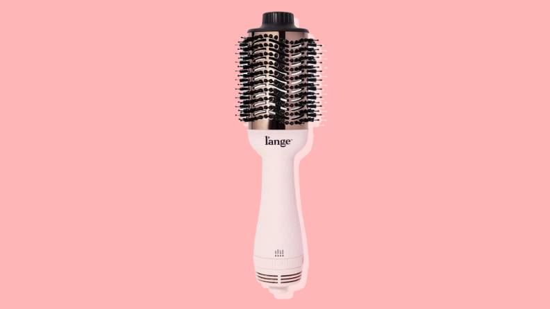 L'Ange hair brush in front of a warm pink background.