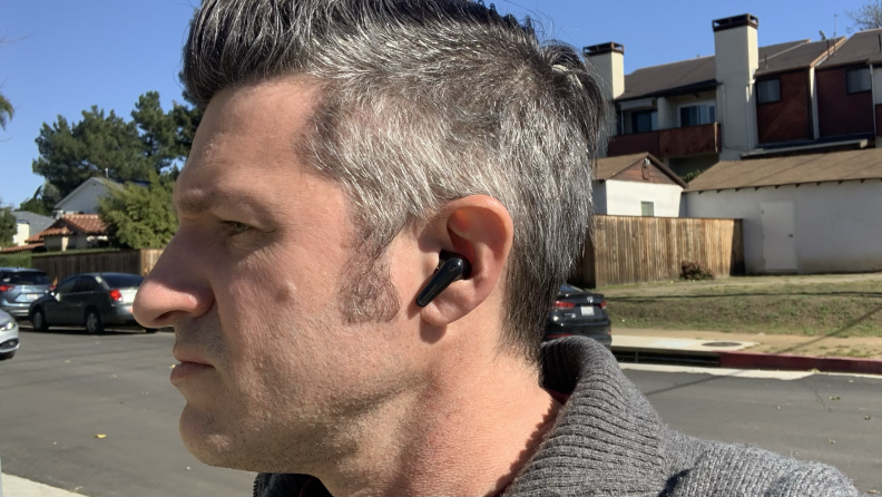 A man standing outside with the Soundcore Liberty 4 on his ears.