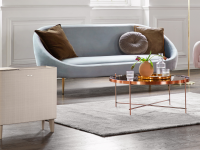 A gold air purifier stands in a living room in front of a blue couch