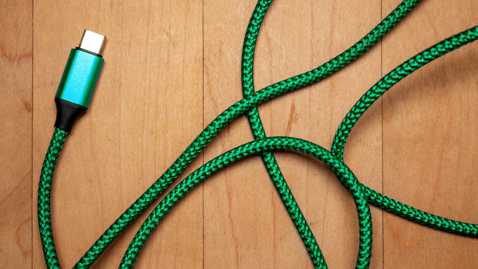 A green cable against a wood floor